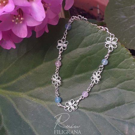 Bracciale in filigrana e pietre naturali, avvolge il polso come una ghirlanda che invita ai piaceri della primavera. Realizzato a mano con cura e passione.