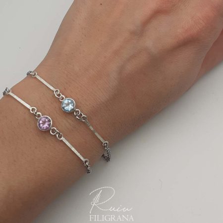 Elegante bracciale con incisione fiorentina, illuminata da ametista o topazio blu, gioiello affascinante realizzato interamente a mano con cura e passione.