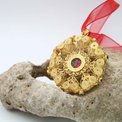 Medaglia in filigrana d'oro, decorata con incisione fiorentina, è l'elemento focale del rosario tradizionale sardo. Realizzata interamente a mano con cura.